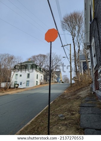 An empty street area in Lunenburg Nova Scotia with a random orange sign on the side of a road.