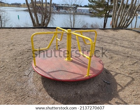 A child's playground with the view of a merry go round. Royalty-Free Stock Photo #2137270607