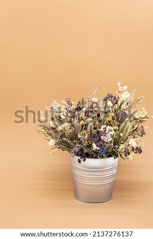 Beautiful dried flowers bouquet in vase against light background. Still life of withered flowers bouquet.