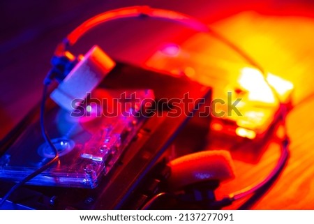 Vintage cassette tape player in neon light. 90s advertisement style. Disco party nostalgy concept Royalty-Free Stock Photo #2137277091