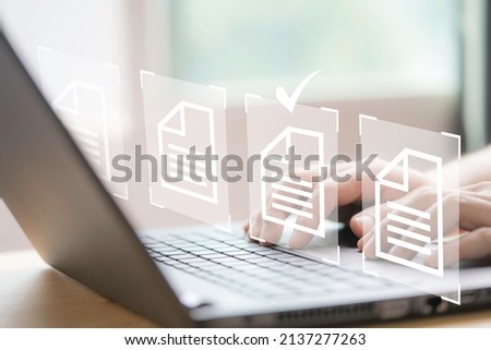 Hand using laptop computer with virtual screen and document for online approve paperless quality assurance and ERP management concept. Royalty-Free Stock Photo #2137277263