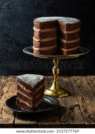 Chocolate layer cake filled with Moka mousse and topped with Icing sugar.
