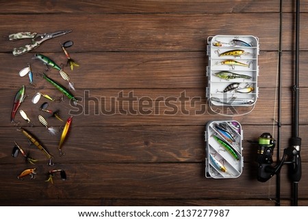 Fishing tackle - fishing spinning rod, hooks and lures on vintage wooden background. Active hobby recreation concept. Top view, flat lay. Copy space for text Royalty-Free Stock Photo #2137277987