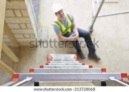 Construction Worker Falling Off Ladder And Injuring Leg Royalty-Free Stock Photo #213728068