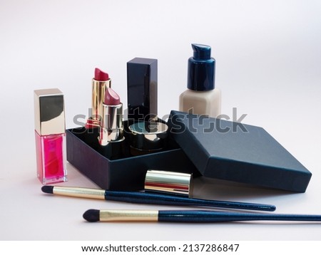 set of cosmetics for a female face and eye makeup in a black craft box on a pink background. photo