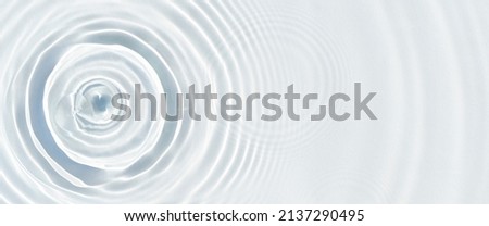 Water droplets fall on the transparent surface of the water in sunlight. Top view, flat lay. Banner.  Royalty-Free Stock Photo #2137290495