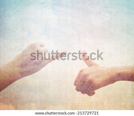 Friends making a pinkie promise. Hands on vintage background. 