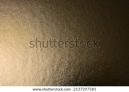 Golden matte paper with a rough surface, gilding with a dark and golden sheen, an exclusive and unusual background.