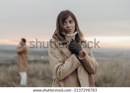 girl in a beige coat on a man's background