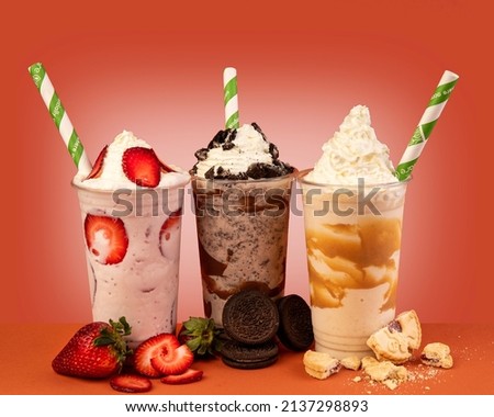 Three glasses of colorful milkshake cocktails - chocolate, strawberry and vanilla decorated with fresh strawberries and mint isolated on colorful background Royalty-Free Stock Photo #2137298893