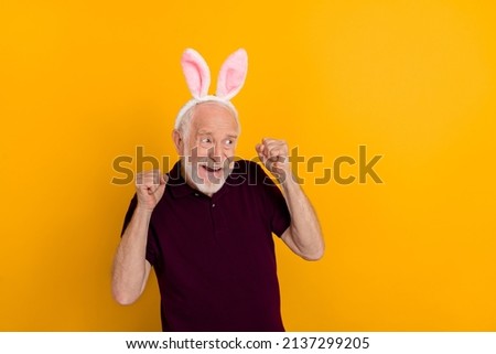 Photo of mature cheerful man fists hands look empty space lucky hooray isolated over yellow color background