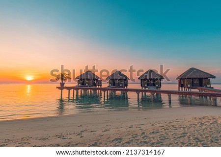 Maldives island sunset. Water bungalows resort at islands beach. Indian Ocean, Maldives. Beautiful sunset landscape, luxury resort villas and colorful sky. Summer vacation holiday and travel concept Royalty-Free Stock Photo #2137314167