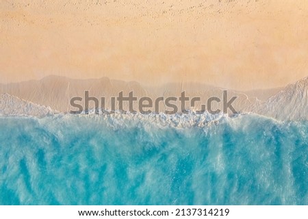 Summer seascape beautiful waves, blue sea water in sunny day. Top view from drone. Sea aerial view, amazing tropical nature background. Beautiful bright sea waves splashing and beach sand sunset light Royalty-Free Stock Photo #2137314219