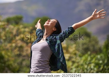 Enjoying the fresh air. Portrait of an attractive young woman celebrating the day outside. Royalty-Free Stock Photo #2137322345