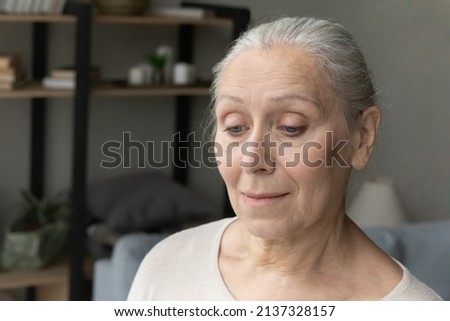 Close up face of upset, frustrated hoary older woman lost in sad thoughts standing alone in living room. Life concerns, lonely senior female portrait, physical or mental disorder of elderly concept Royalty-Free Stock Photo #2137328157