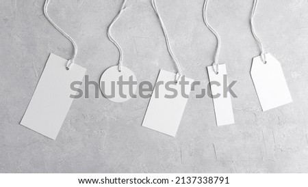 Round tag mockup, rectangle tag mockup, strip tag mockup with white cord, close up. Various price cardboard labels on grey background. Blank empty paper product tags, sale and black friday concept Royalty-Free Stock Photo #2137338791