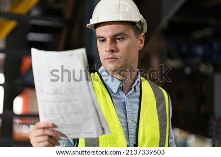 Engineer or foreman hard work with paperwork and machine at factory	