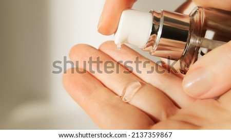 Push dispenser liquid facial fluid gel squeezed out to hand. Cosmetologist pours clear cleansing moisturizing hyaluronic serum acid. Cosmetic concept. Royalty-Free Stock Photo #2137359867