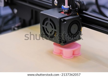 Automatic three dimensional printer machine printing pink plastic model - close up. Equipment, prototype, manufacturing and production concept Royalty-Free Stock Photo #2137362057