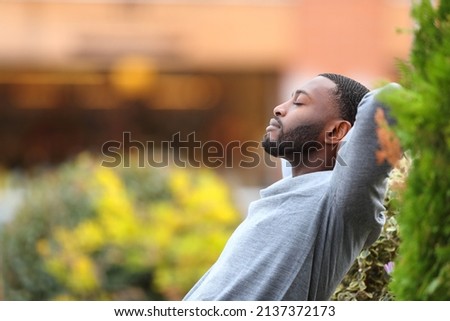 Side vie wportrait of a relaxed man with black skin resting in a park Royalty-Free Stock Photo #2137372173