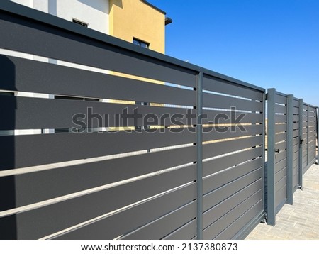 Modern metal fence for fencing the yard area. Horizontal sections of the fence made of metal Royalty-Free Stock Photo #2137380873
