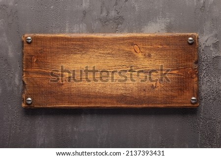 Wooden nameplate or sign board screwed on wall background. Front view of name plate Royalty-Free Stock Photo #2137393431