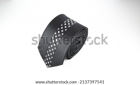 black color polyester necktie isolated rolled with white background for e-commerce and commercial purposes 