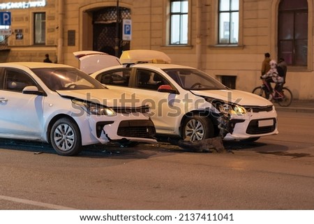 Two cars on the city road after collision. Damaged white automobile on the street after the accident with damaged bumpers, side view.  Royalty-Free Stock Photo #2137411041
