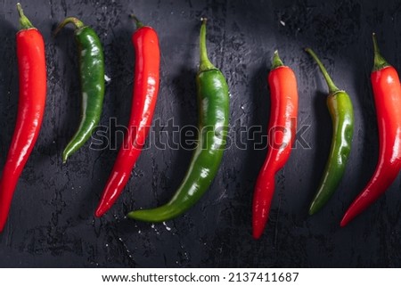 Red and green chili peppers on dark rustic background