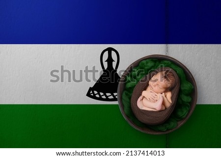 Newborn portrait on background in color of national flag. Patriotic photography concept. Lesotho