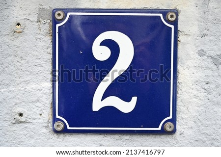 A blue house number plaque, showing the number two (number 2)  Royalty-Free Stock Photo #2137416797