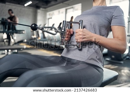 Sporty woman using gym workout equipment in fitness center