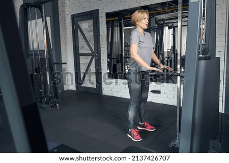 Sporty woman using gym trainer during strength workout
