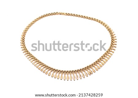 A collection of gold chains and jewellery. Photographed on a light background.