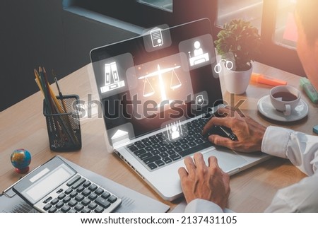 Justice and law concept, Male judge working on laptop computer with VR screen law icon background.