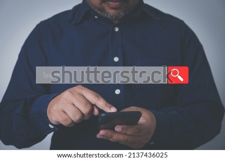 Businessman using hands touching at a smartphone with search icon for Search Engine Optimisation or SEO. Finding a website by internet online connection.