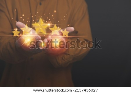 Businessman holding virtual five yellow stars on hands. Evaluation the customer satisfaction and service. Products and service evaluation concept.