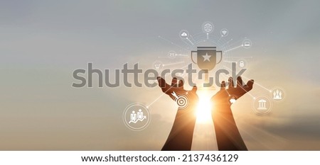 
hands businessman touching a trophy of winner award and business icon of marketing on sunset background. business target. business goal success. Royalty-Free Stock Photo #2137436129