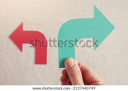 Hand holding right green arrow with red left arrow, change management, disruption, economy crisis, stagflation, business concept