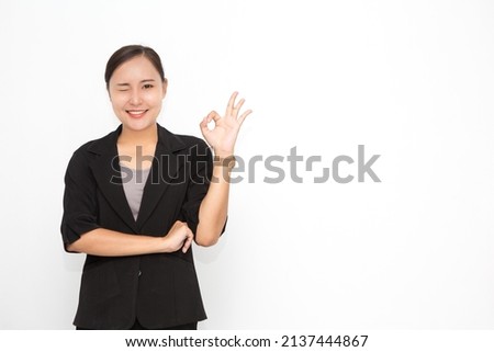 Beautiful Asian business woman wearing black suit okay sing presenting something on white background and copy space. Confident Asian working woman smiling and cheerful