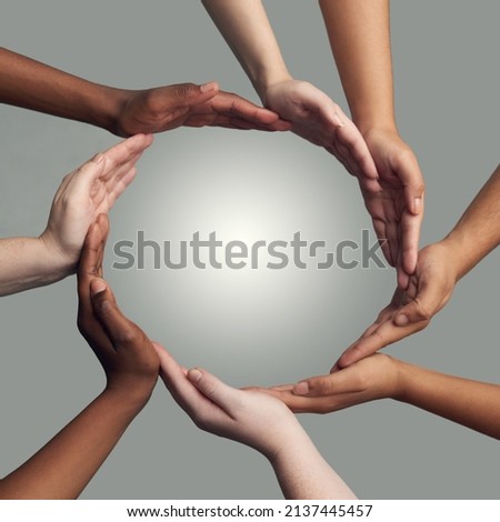 Coming together to form one. Cropped shot of a group of hands linking together to form a circle against a grey background. Royalty-Free Stock Photo #2137445457