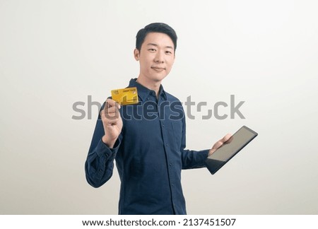 portrait young Asian man holding credit card and tablet on white background