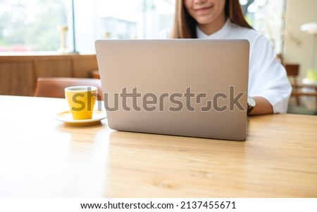 Closeup image of a young woman using and working on laptop computer
