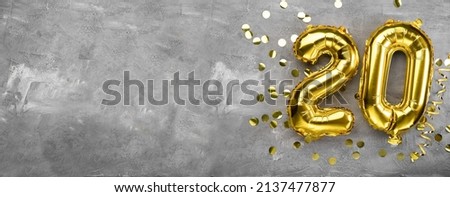 Yellow foil balloon number, number twenty on a concrete background. Birthday card with inscription 20. Anniversary concept. for anniversary, birthday, new year celebration. banner, copy space. Royalty-Free Stock Photo #2137477877