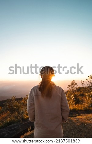 Woman looking at beautiful mountain valley in fog at sunrise and flare in summer, Travel and tourism.