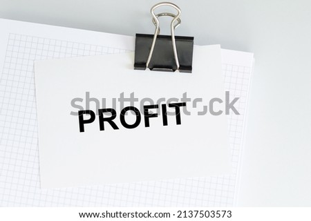 PROFIT inscription on the card on the clip to the notebook, business concept
