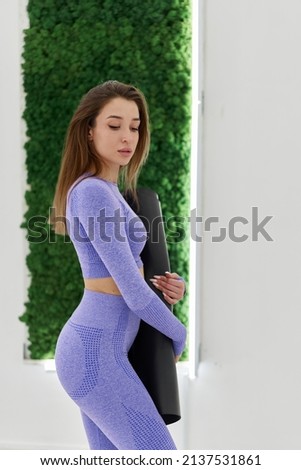 Woman in trendy colour sportswear holding sports