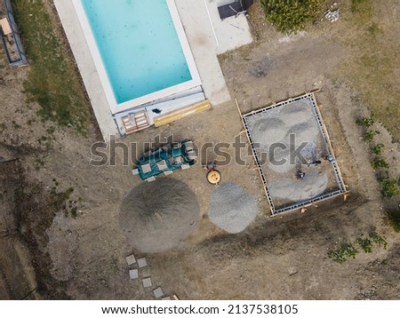 Drone shot of pool construction site with sheeting and gravel for a concrete pad for pool house in march