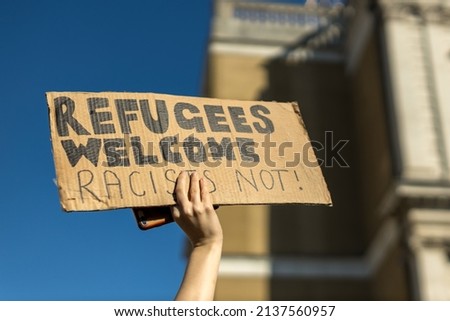 A protestor holding an anti racist-pro refugee placard at the march against racism protest in London.