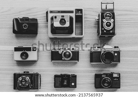 Vintage photo cameras on wooden background. Black and white.